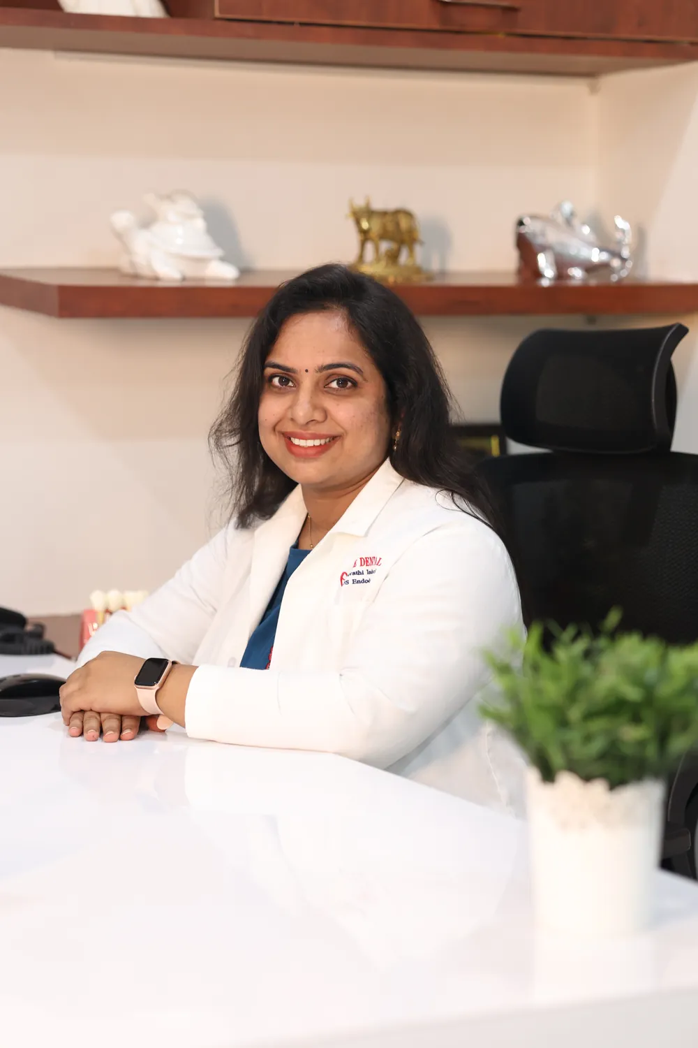 Dr. Revathi Indukuri seated at the consultation desk at Elite Dental Clinic, Kondapur